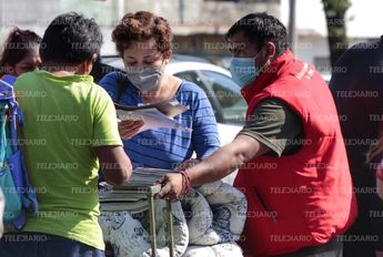 Una mujer revisa sus documentos personales tras rescatarlos de su casa que resultó afectada / Melanie Torres