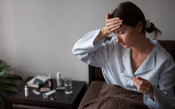 Mujer con fiebre en una cama / Freepik