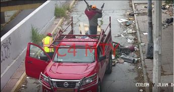 Hombres tirando muebles y desechos sobre la avenida Cristóbal Colón en Monterrey. | Cortesía