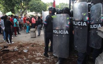 Policías se protegen de los pobladores de La Resurrección que los agredieron / Melanie Torres