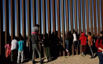 Personas en la frontera frente al muro que divide México de Estados Unidos. | Reuters