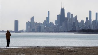 Una persona se abriga bien mientras toma fotos durante un día de clima frío en el lago Michigan en Chicago (Foto AP/Nam Y. Huh)