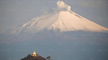 Aspecto el volcán Popocatépetl junto a un cerro y una iglesia a lo lejos / Andrés Lobato