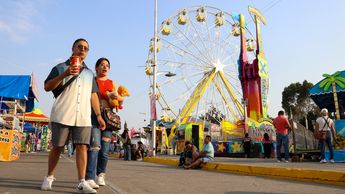 Aspecto de la Feria de Puebla 2025 con los juegos mecánicos y un atardecer de fondo / Agencia Es Imagen