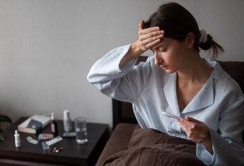 Mujer con fiebre en una cama / Freepik
