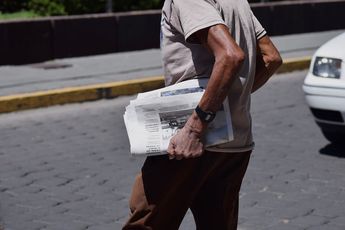 Un señor camina por las calles de Puebla con un periódico impreso en las mano / Agencia Es Imagen