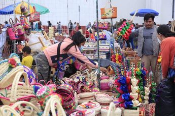 Una mujer acomoda sus artesanías en su puesto en el mercado del trueque / Andrés Lobato