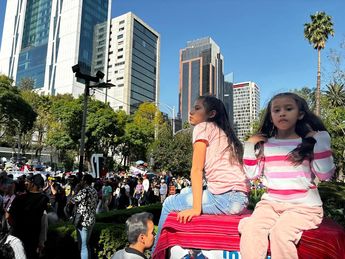 Niñas encuentran el mejor lugar para disfrutar el desfile. / Graciela Olvera