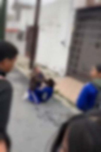 Mujeres jóvenes estudiantes peleando en el suelo sobre la vía pública. | Cortesía