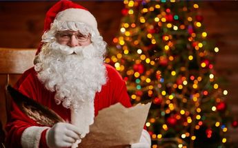 Santa Claus frente a un árbol de Navidad / Shutterstock