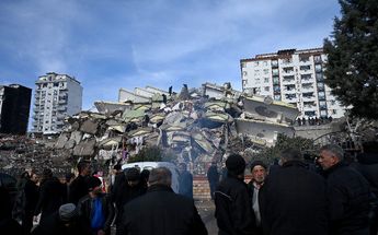 Las familias esperan entre los escombros de los edificios en Kahramanmaras, cerca del epicentro del terremoto, después de que un terremoto de magnitud