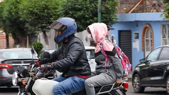 Padre lleva a su hija a la escuela en moto y bien cubiertos por las bajas temperaturas / Es Imagen