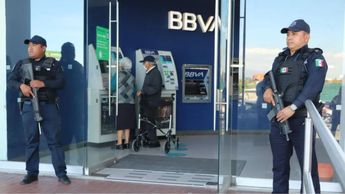 Un oficial de la Policía Estatal de Puebla brinda acompañamiento a ciudadanos frente a una sucursal bancaria, como parte del servicio gratuito / SSP