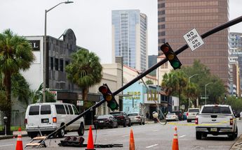 Un semáforo dañado se inclina hacia la carretera después del huracán Ian en Orlando, Florida, el 29 de septiembre de 2022 / AFP