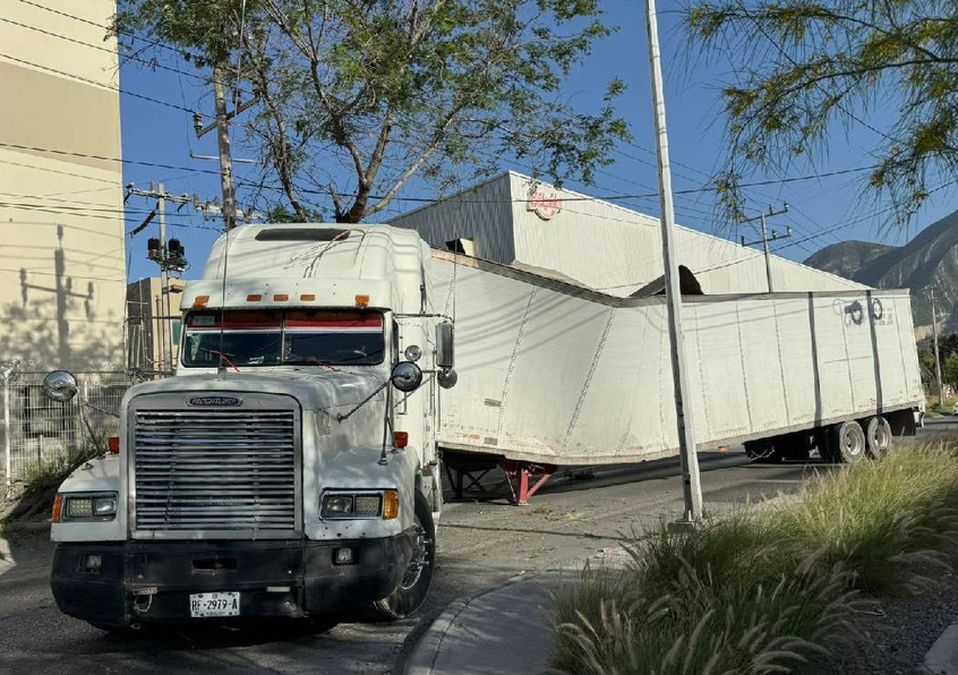 Tráiler queda atorado al pasar por árbol en colonia El Frutal en Santa Catarina. | Marcela Cuevas