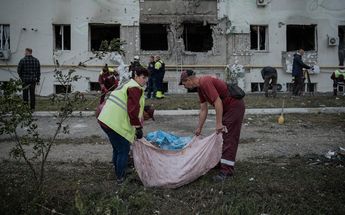Trabajadores municipales limpian escombros frente a un edificio residencial destruido tras un ataque aéreo en Járkov | AFP