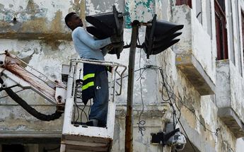 Un hombre repara un semáforo en La Habana, el 29 de septiembre de 2022, tras el paso del huracán Ian / AFP