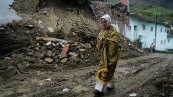 Mujer camina frente a casa que resultó dañada por un terremoto al sureste de Bogotá | AP