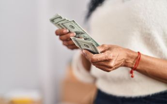 Persona con billetes de dinero en sus manos / Freepik