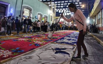 Una artesana realiza un tapete de aserrín para la procesión de la Virgen de la Caridad / Melanie Torres