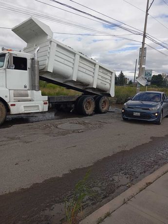 Un camión con escombro fue contratado por vecinos de Coronango para reparar los baches de la zona / Cortesía