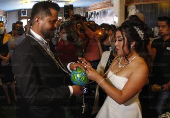 La pareja dijo sus votos sosteniendo un balón como parte de la misa de la Iglesia Maradoniana / Melanie Torres