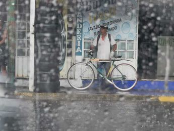Hombre se resguarda de la lluvia en San Andrés Cholula, Puebla / Melanie Torres