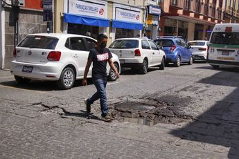 Peatón cruza en calle en mal estado en Puebla | Melanie Torres