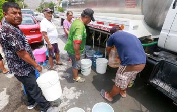 Personas llenando cubetas de agua para acarrear a sus hogares. | Archivo