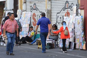Dos vendedores ambulantes esperan atraer clientes en la zona centro de Puebla / Agencia Es Imagen