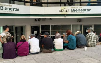 Adultos mayores sentados afuera del Banco de Bienestar. | Marcela Cuevas