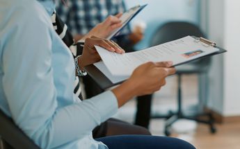 Mujer escribe en su CV su experiencia como ama de casa / Freepik