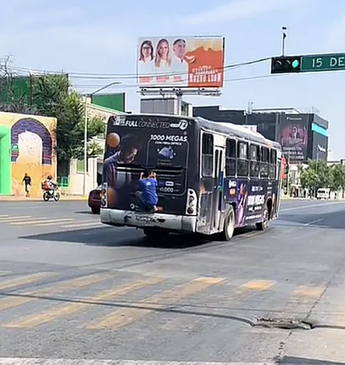 Hombre colgado de camión de ruta urbana en el Centro de Monterrey. | Cortesía