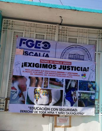La papeleta de suspensión y una pancarta que exije justicia se aprecian en la entrada del colegio Francoise Dolto
