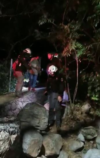 Elementos de Protección Civil culminando el descenso con el joven. | Cortesía