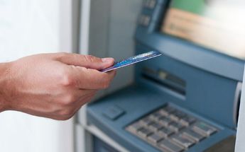 Persona insertando una tarjeta en un cajero / Freepik