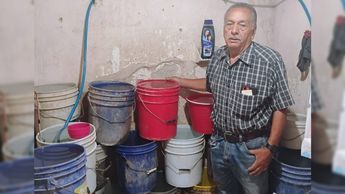 Don Francisco con sus cubetas de agua en el baño / Diana Barajas