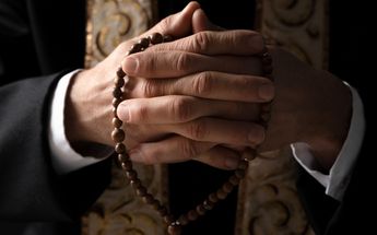 Persona con un rosario en manos / Freepik
