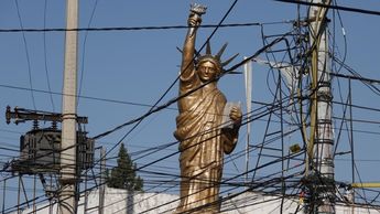 Una réplica de la Estatua de la Libertad entre cables en CdMx