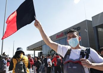 Un trabajador de Audi México levanta una bandera rojinegra por el estallamiento de huelga en la planta de Puebla / Agencia Es Imagen