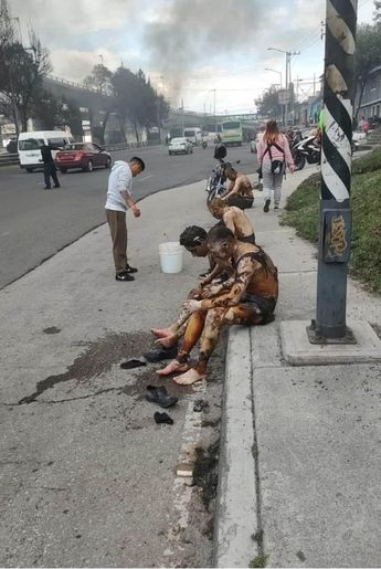 Personas rescatadas tras la explosión reposan tras haber salido del fuego en el puente La Concordia / Agencia Cuartoscuro
