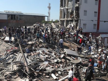 Residentes y equipos de rescate buscan entre los escombros de un edificio derrumbado tras el terremoto que azotó Cali.