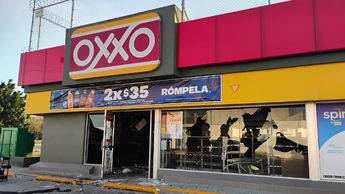La tienda de la cadena OXXO presentó múltiples impactos de bala en la fachada y cristales tras el ataque | Foto: Gloria Reza