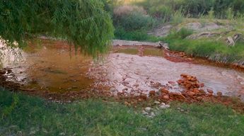 El agua del río ha tomado un tono rojizo.
