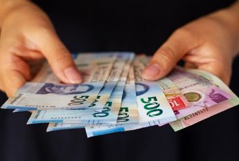 Persona agarrando billetes mexicanos / Freepik