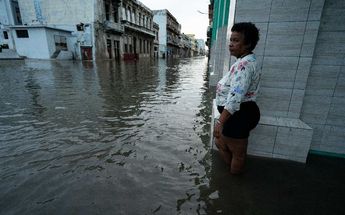 Una mujer de pie en una calle inundada de La Habana, el 28 de septiembre de 2022, tras el paso del huracán Ian / AFP