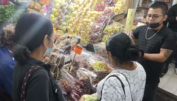 Un comerciante vende uvas a clientes en el Mesón Estrella. | Fabricio Gallegos