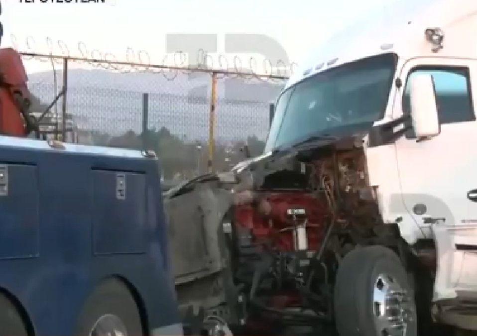 Autoridades realizan labores para retirar la unidad de carga que fue asaltada por delincuentes.