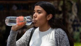 Una joven bebe agua para hidratarse debido al calor de la canícula en Puebla / Agencia Es Imagen